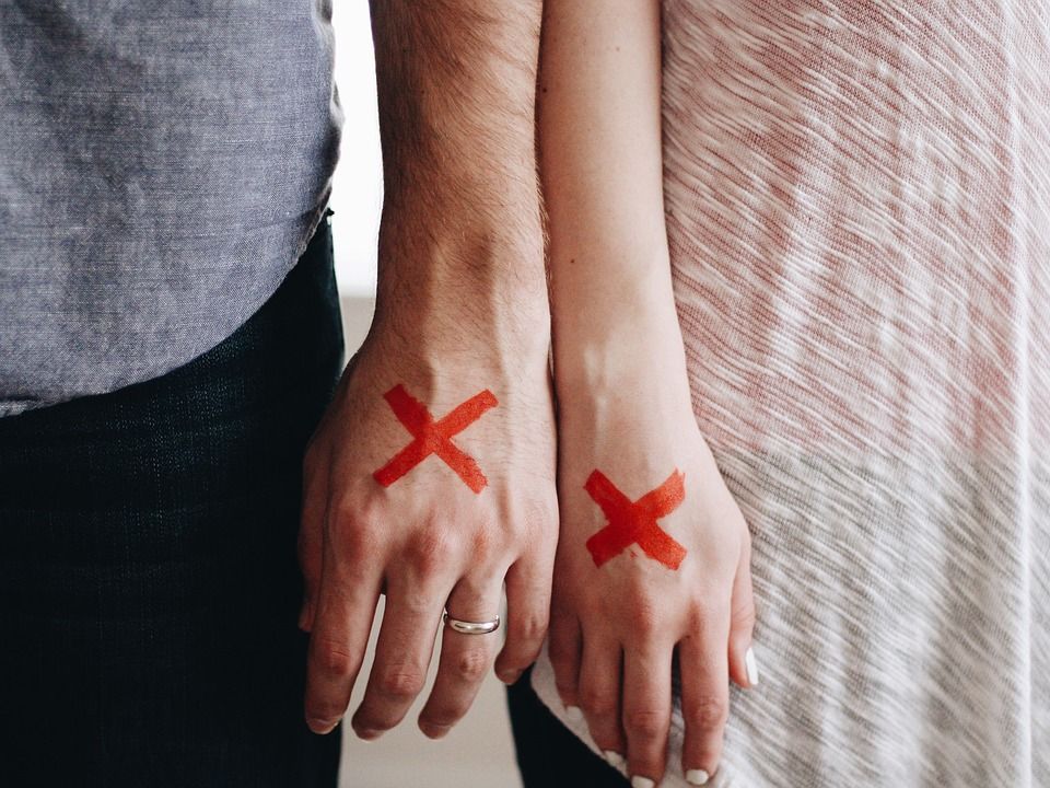 couple with red X on hands