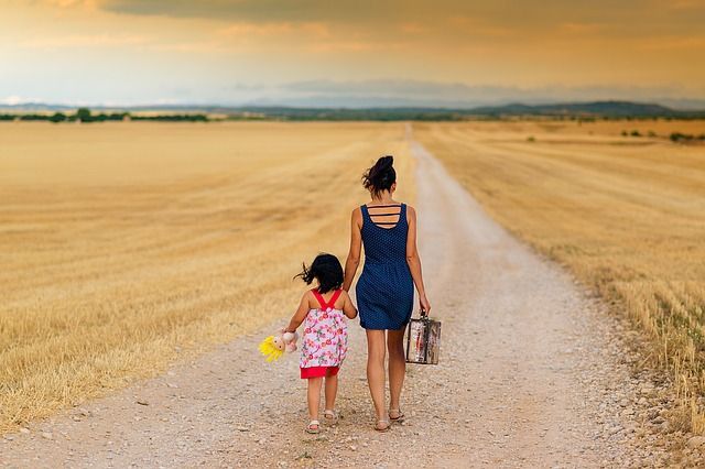 mom and daughter walk down road