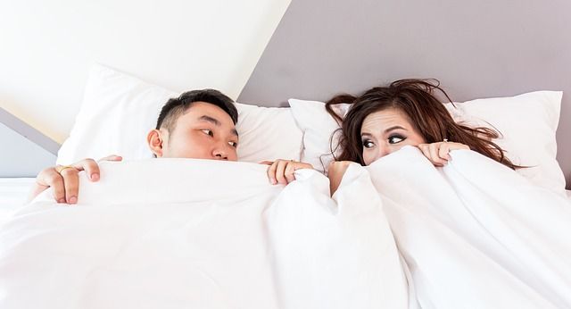 couple hiding under covers