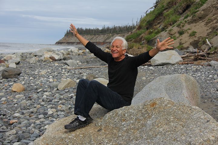 old man happy on rocks